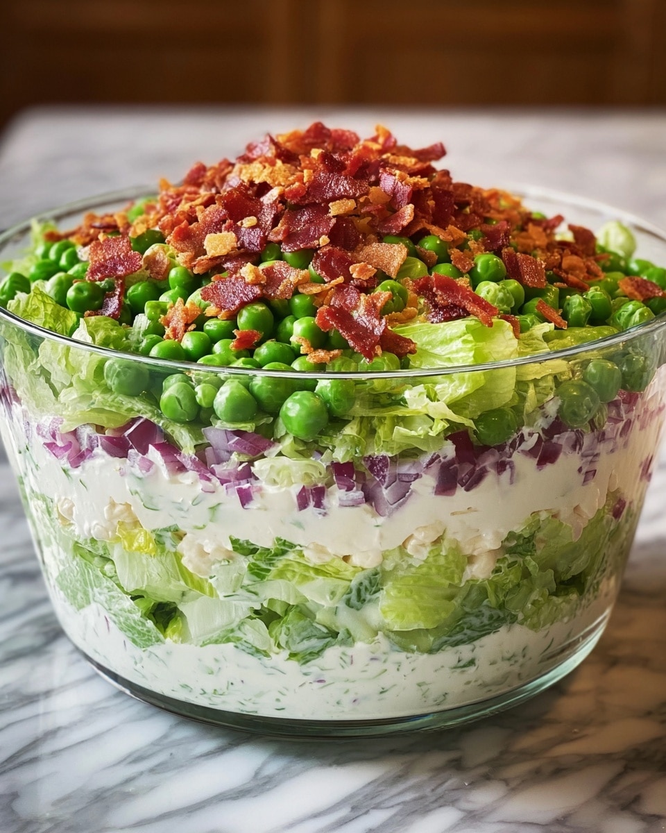 A clear glass bowl shows a colorful salad with six visible layers. The bottom layer is light green chopped lettuce, followed by a thick white creamy layer. Above that is a layer of slightly darker green chopped lettuce, then another thick white creamy layer. Next is a layer of chopped red onions mixed with a bit of white cream, topped by a bright green layer of whole peas. The salad is finished with a generous sprinkle of small reddish-brown bacon pieces and crispy crumbs. The bowl is set on a white marbled surface, and the photo is taken with an iphone --ar 4:5 --v 7