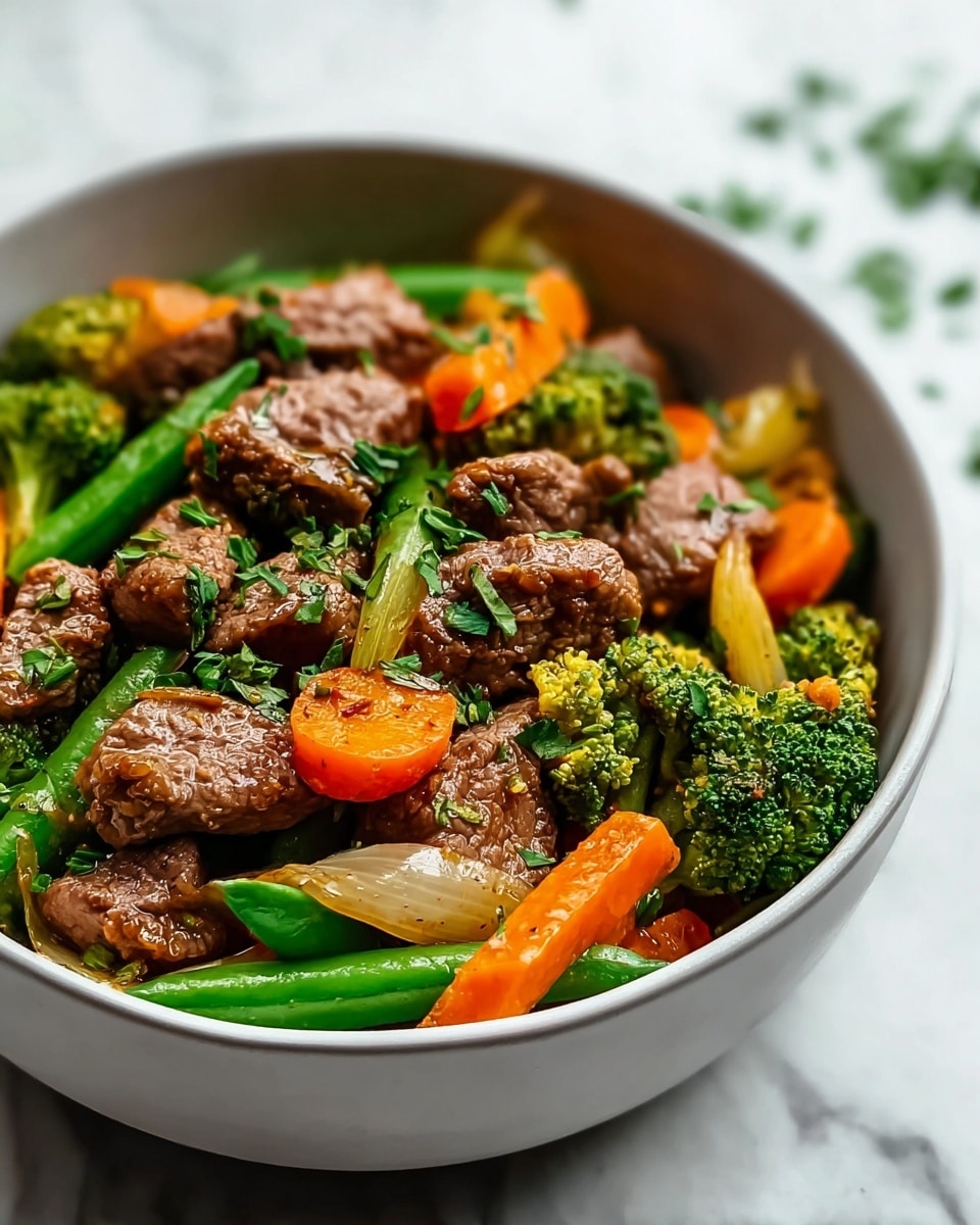 A bowl filled with a colorful beef stir-fry dish, showing about three layers: the bottom layer has bright green snap peas and small broccoli florets with textured, bumpy surfaces; the middle layer features orange carrot slices and translucent yellow onion pieces with a slightly shiny look; the top layer is made up of tender brown beef chunks with a slightly glossy finish, garnished with small chopped green herbs scattered on top. The bowl is white with a simple design, placed on a white marbled surface. photo taken with an iphone --ar 4:5 --v 7
