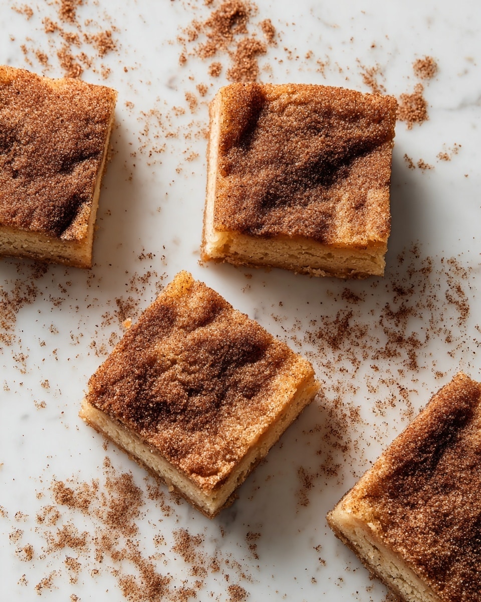 Five square pieces of cinnamon sugar cake are placed on a white marbled surface. Each piece has two visible layers: a soft, light brown bottom cake layer and a top layer thickly covered with a cinnamon and sugar mix that gives a grainy, slightly rough texture and a darker brown color. Some cinnamon sugar is scattered around the cake squares on the white marbled background, adding a rustic look. The cake pieces are cut evenly and look moist with a slightly crumbly edge. photo taken with an iphone --ar 4:5 --v 7