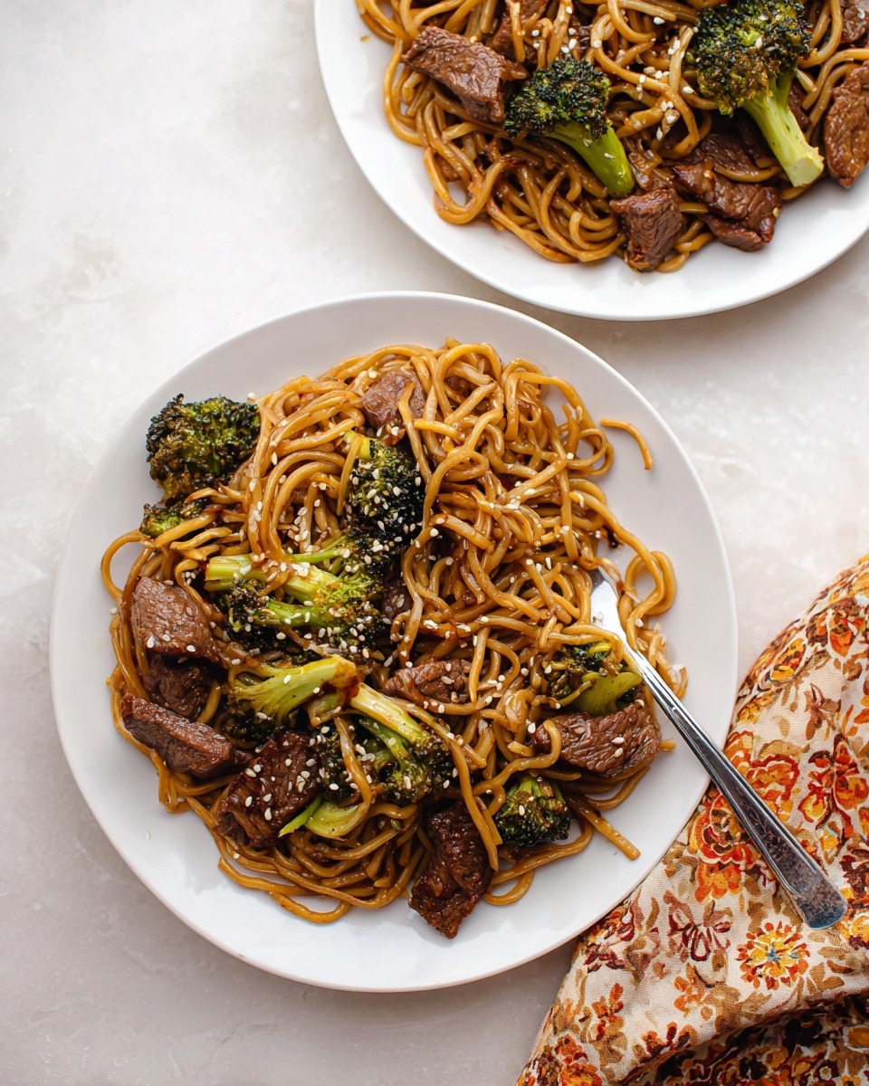 The image shows a black pan filled with glossy brown stir-fried noodles mixed with bright green broccoli pieces and browned, juicy slices of beef scattered evenly on top. The noodles are long and silky, glistening with sauce, and intertwined with the small broccoli florets. The beef pieces vary in size and have a caramelized, slightly crispy exterior, resting on and among the noodles and vegetables. A black spatula is partially visible at the bottom right side of the pan, lying on the noodles. The pan handle has a wooden grip, and everything is set on a white marbled surface. photo taken with an iphone --ar 4:5 --v 7