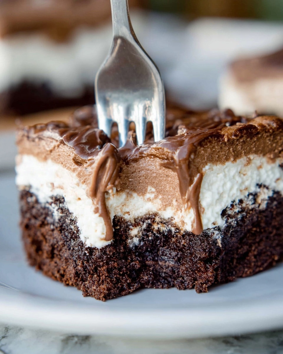 The image shows a close-up of a dessert with three distinct layers on a white plate over a white marbled surface. The bottom layer is dark brown and dense, resembling a rich chocolate brownie with a slightly crumbly texture. Above it is a thick, creamy white layer that looks soft and fluffy, with part of it melting and dripping down the sides. The top layer is a smooth milk chocolate spread, slightly glossy with a swirled texture from being spread. A silver fork is pressed into the dessert from above, creating an indentation in the chocolate layer, with the fork’s prongs partially sunk in. The background is blurred, emphasizing the dessert in the foreground. Photo taken with an iphone --ar 4:5 --v 7